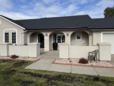 Exterior painting, beige stucco front with arches, black roof, white garage, Elements Painting project on the Colorado Front Range