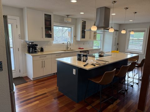 Cabinet painting, bright white kitchen with navy island and leather stools, Elements Painting project on the Colorado Front Range