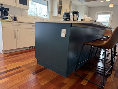 Cabinet painting, navy island end with leather stools, white cabinets behind, Elements Painting project on the Colorado Front Range
