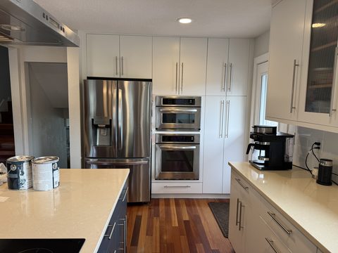 Cabinet painting, white tall cabinets with stainless fridge and wall ovens, Elements Painting project on the Colorado Front Range