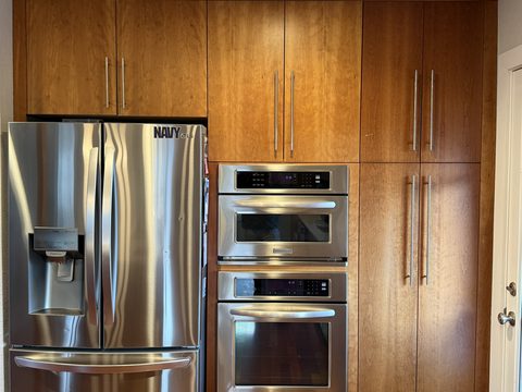 Cabinet painting, wood-tone cherry cabinets with stainless fridge and wall ovens, Elements Painting project on the Colorado Front Range