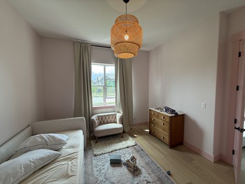 Interior painting, bedroom with pale blush walls, rattan pendant, daybed, armchair, wood dresser, Elements Painting project on the Colorado Front Range