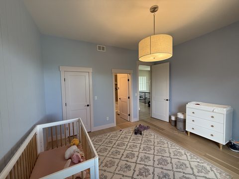 Interior painting, nursery with light blue walls, white trim, crib, white dresser, drum pendant, Elements Painting project on the Colorado Front Range