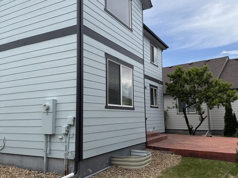 Exterior painting, pale blue siding rear corner, dark gray trim, brick patio, Elements Painting project on the Colorado Front Range