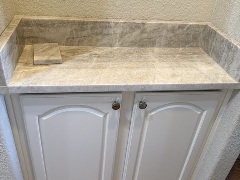 Cabinet painting, white raised-panel vanity cabinet, gray marble countertop, small nook, Elements Painting project on the Colorado Front Range