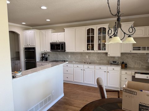 Cabinet painting, white kitchen cabinets, beige walls, pendant light, Elements Painting project on the Colorado Front Range