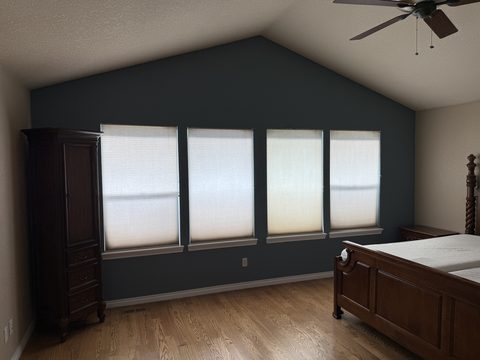 Interior painting, bedroom with dark teal accent wall, vaulted ceiling, four windows, beige side walls, Elements Painting project on the Colorado Front Range