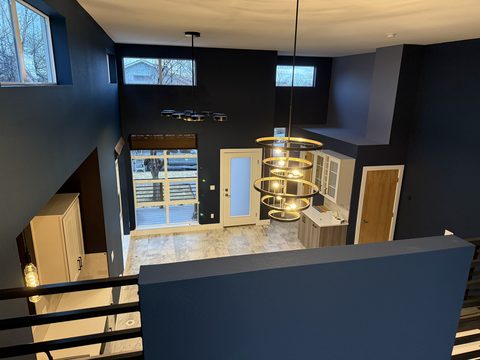 Interior painting, two-story great room from loft, navy walls, white ceiling, ring chandelier, light wood floor, Elements Painting project on the Colorado Front Range