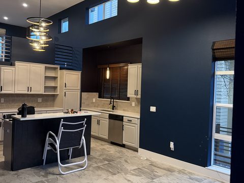 Interior painting, kitchen, navy walls, cream cabinets, island, pendant lights, Elements Painting project on the Colorado Front Range