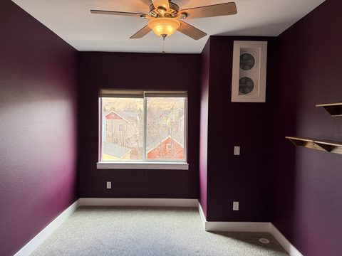 Interior painting, deep plum bedroom, white trim, ceiling fan, grey carpet, Elements Painting project on the Colorado Front Range