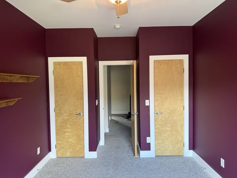 Interior painting, burgundy bedroom with birch doors, white trim, wall shelves, grey carpet, Elements Painting project on the Colorado Front Range