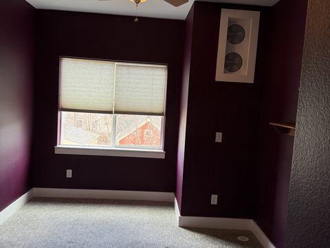 Interior painting, dark plum bedroom, window with cellular shades, white baseboards, Elements Painting project on the Colorado Front Range