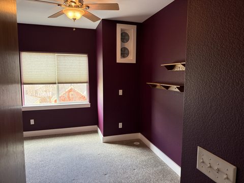 Interior painting, plum bedroom with floating shelves, ceiling fan, window, grey carpet, Elements Painting project on the Colorado Front Range