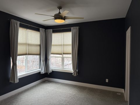 Interior painting, dark navy bedroom with curtains, ceiling fan, grey carpet, Elements Painting project on the Colorado Front Range
