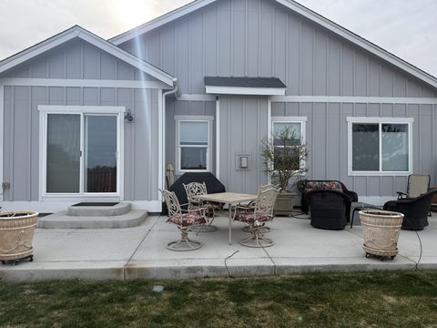 Exterior painting, grey board-and-batten rear exterior, white trim, patio furniture, Elements Painting project on the Colorado Front Range