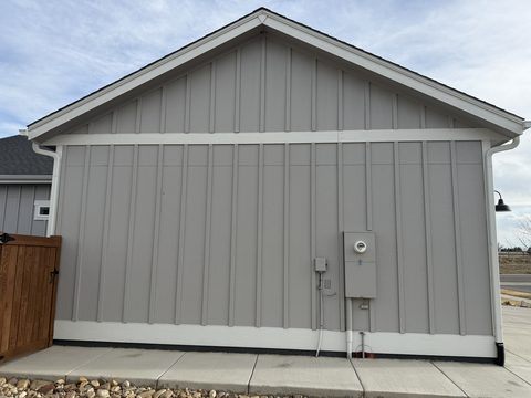 Exterior painting, grey board-and-batten garage side wall, white trim, utility meter, Elements Painting project on the Colorado Front Range