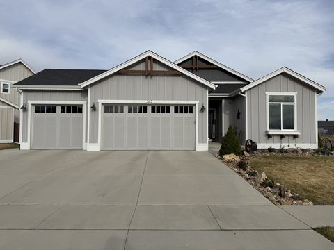 Exterior painting, grey board-and-batten house front, three-car garage, white trim, Elements Painting project on the Colorado Front Range