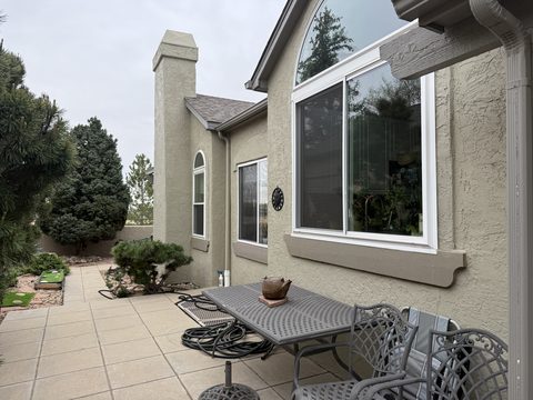 Exterior painting, tan stucco exterior with white window trim, patio dining set, Elements Painting project on the Colorado Front Range