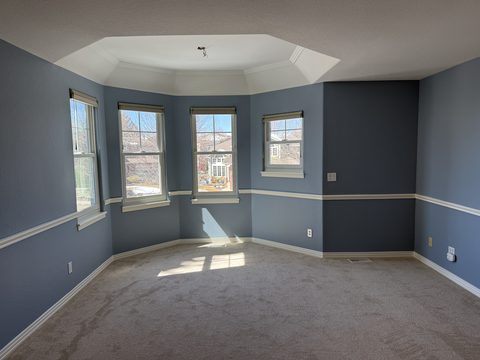Interior painting, blue-grey walls, white chair rail, tray ceiling, bay windows, carpeted bedroom, Elements Painting project on the Colorado Front Range