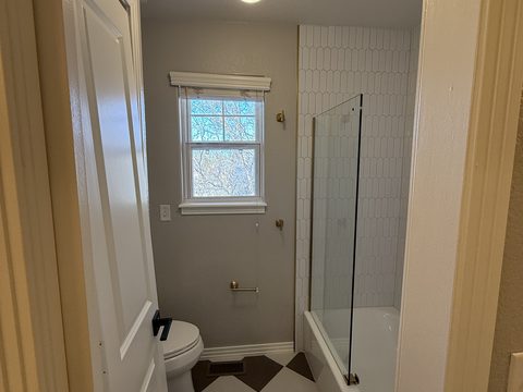 Interior painting, light grey bathroom, white tile shower, glass panel, window, Elements Painting project on the Colorado Front Range