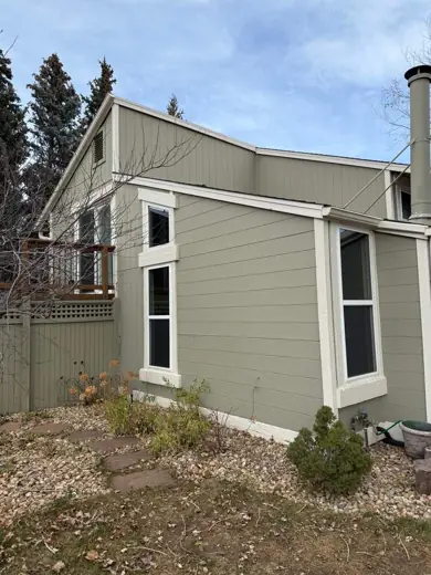 Gray-green home exterior with dark window trim, blue sky, Elements Painting project on the Colorado Front Range