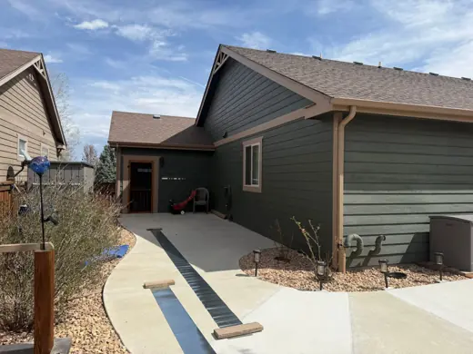 Gray-green house exterior with brown trim beside concrete walkway, Elements Painting project on the Colorado Front Range