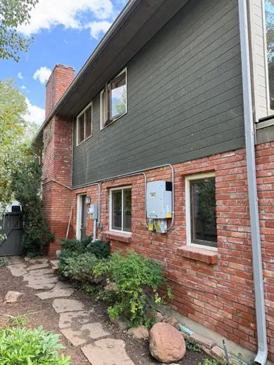 Gray-green house with red brick base and wood trim, Elements Painting project on the Colorado Front Range