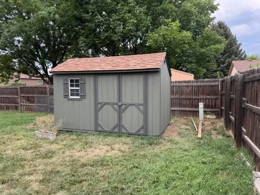Gray shed with brown trim and wood fence, Elements Painting project on the Colorado Front Range
