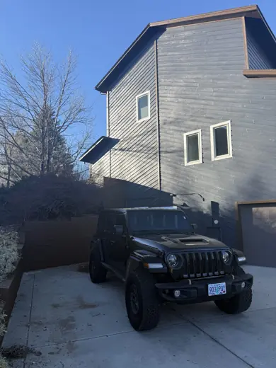 Gray two-story home from driveway with vehicle, Elements Painting project on the Colorado Front Range