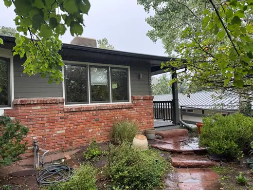 Green ranch home with brick planter and deck, Elements Painting project on the Colorado Front Range