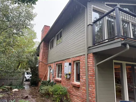 Green siding with brick lower level and balcony, Elements Painting project on the Colorado Front Range