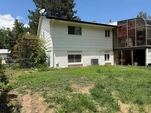 Green split-level home with sunroom, before work, Elements Painting project on the Colorado Front Range