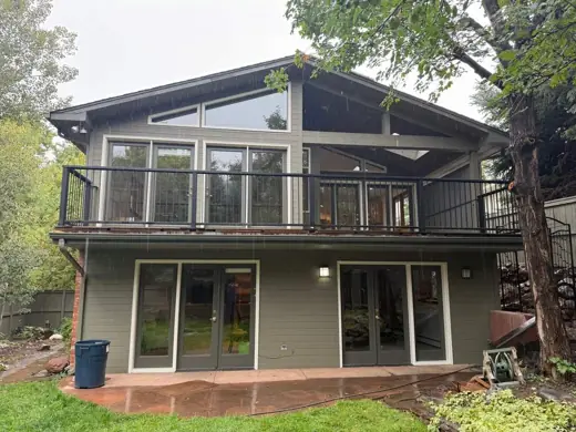 Green two-story home with deck and sliding doors, Elements Painting project on the Colorado Front Range