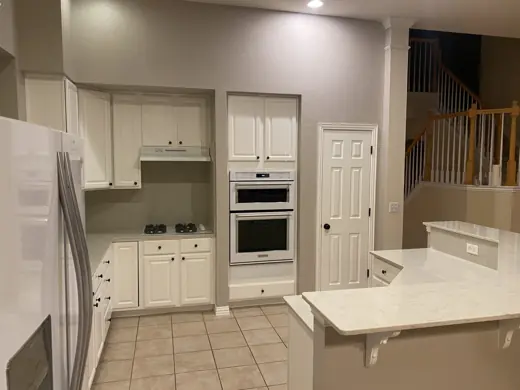 Kitchen with white painted cabinets and gray tile floor, Elements Painting project on the Colorado Front Range