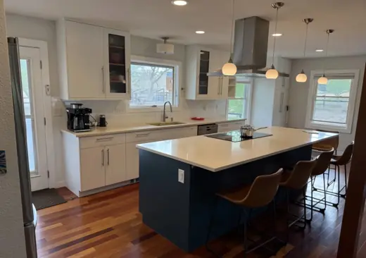 Kitchen with white uppers and dark blue island, hardwood floors, Elements Painting project on the Colorado Front Range