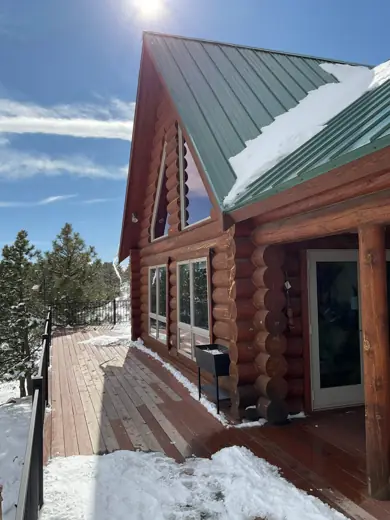 Log cabin corner with green metal roof and snow, Elements Painting project on the Colorado Front Range