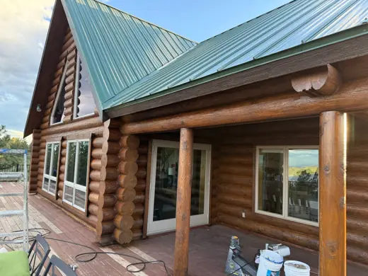 Log home deck with green roof and stained log posts, Elements Painting project on the Colorado Front Range