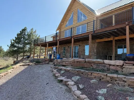 Log home with wraparound deck and rock landscaping, mountain setting, Elements Painting project on the Colorado Front Range