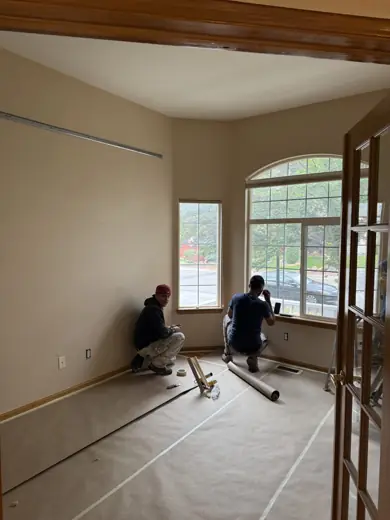 Painters prepping large windows and walls in bright room, Elements Painting project on the Colorado Front Range