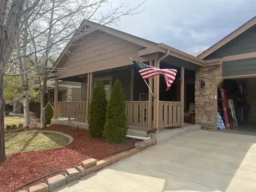 Ranch home with brown siding, flag, and covered wood porch, Elements Painting project on the Colorado Front Range