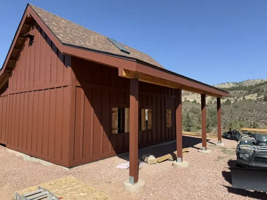Rust red barn with covered porch and brown roof, Elements Painting project on the Colorado Front Range