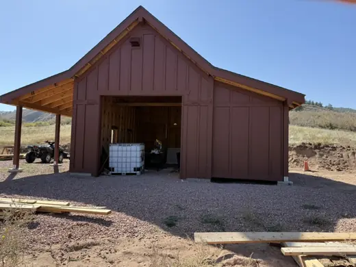 Rust red barn with wood posts, open door, Elements Painting project on the Colorado Front Range