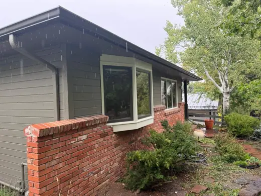 Sage green ranch home, cream fascia, brick planter, Elements Painting project on the Colorado Front Range