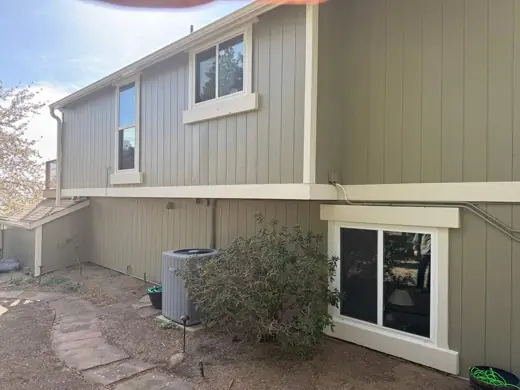 Sage green siding with cream trim, rear corner and window, Elements Painting project on the Colorado Front Range