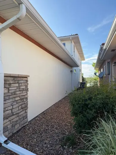 Side of white stucco home with stone base, Elements Painting project on the Colorado Front Range