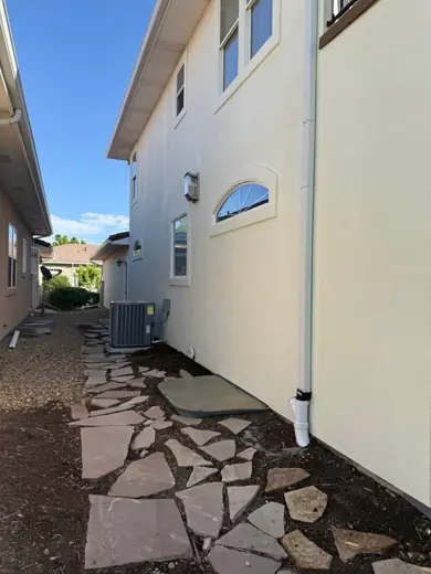 Side of white stucco home with stone path, Elements Painting project on the Colorado Front Range