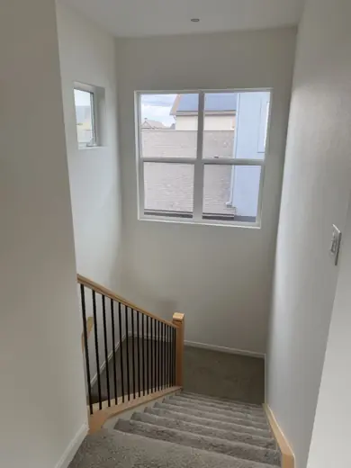 Stair landing with window and metal railing, white walls, Elements Painting project on the Colorado Front Range
