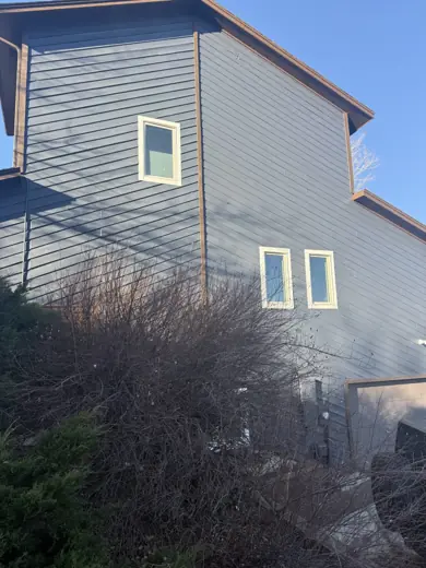 Tall gray sided home with white trim and yellow accent window, Elements Painting project on the Colorado Front Range