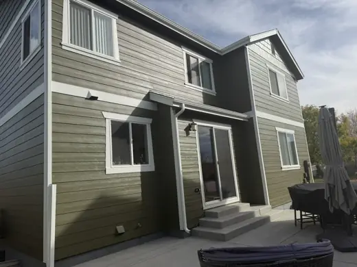 Tan two-story home with white trim and sliding door, Elements Painting project on the Colorado Front Range