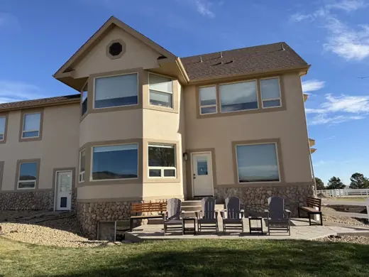Tan two-story stucco home with white trim and patio, Elements Painting project on the Colorado Front Range